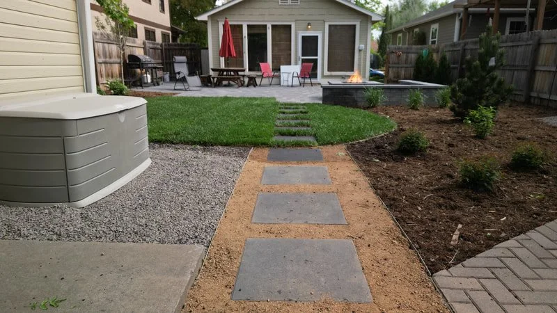 Finished Hurr Vasa backyard in Fort Collins with a paver walkway, fresh sod, and a patio with a fire pit